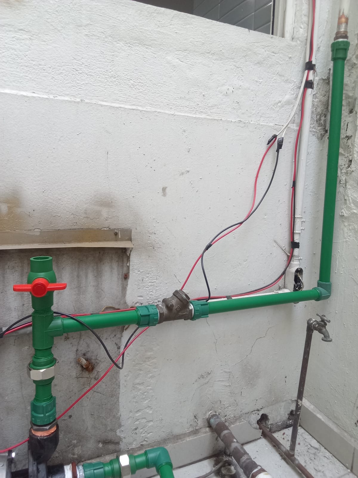 Tuberías y conexiones en muro blanco